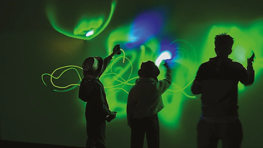 Guests painting glowing lines inside Light Art Box